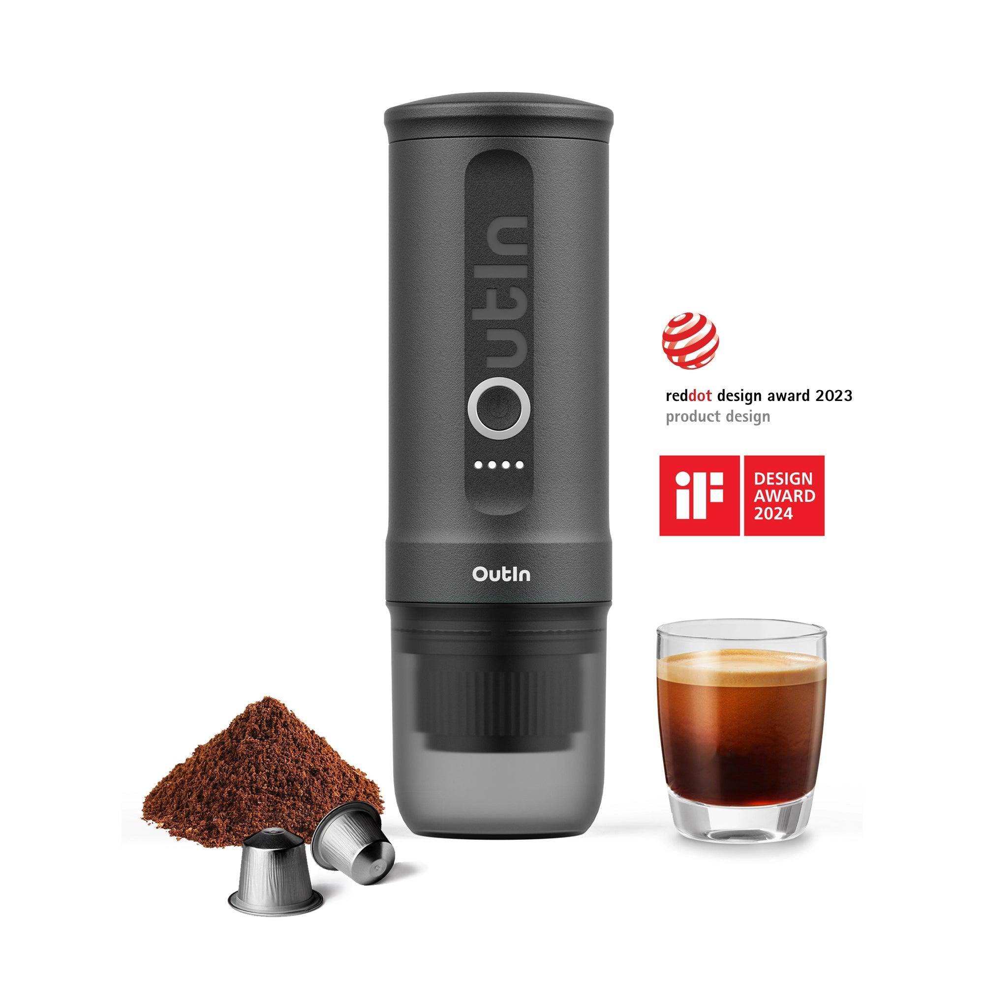 Dark-grey OutIn portable espresso maker with espresso glass, ground coffee, capsules and award artwork